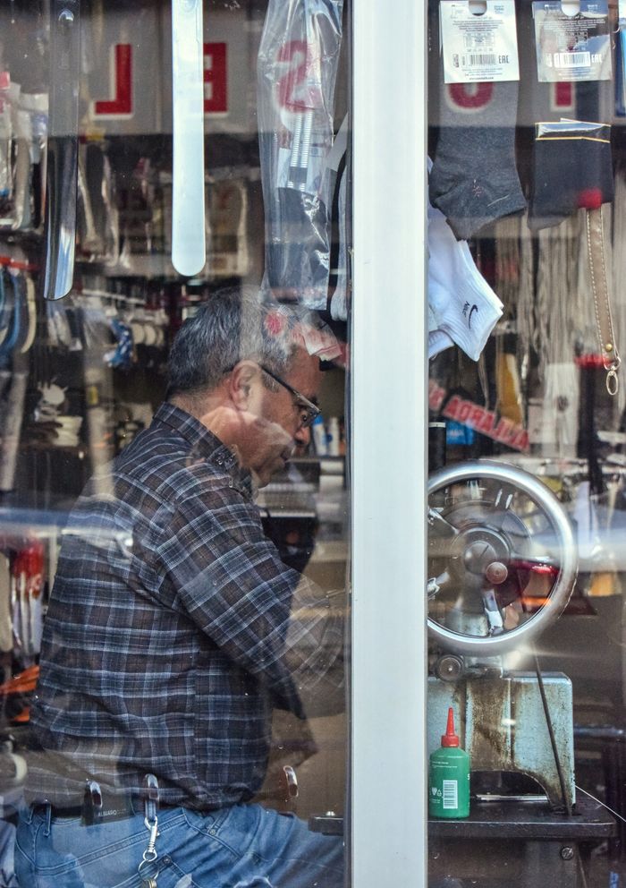 A dedicated tailor works meticulously with sewing tools in a workshop.